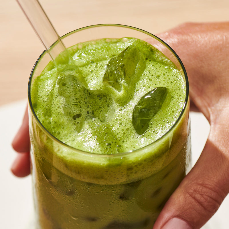 Hand holding Clevr matcha in a glass