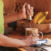 Person making Clevr SuperLatte using a Clevr frother to mix it in a kitchen