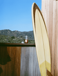 Clevr Shaker Bottle pictured outside on a deck with a surf board