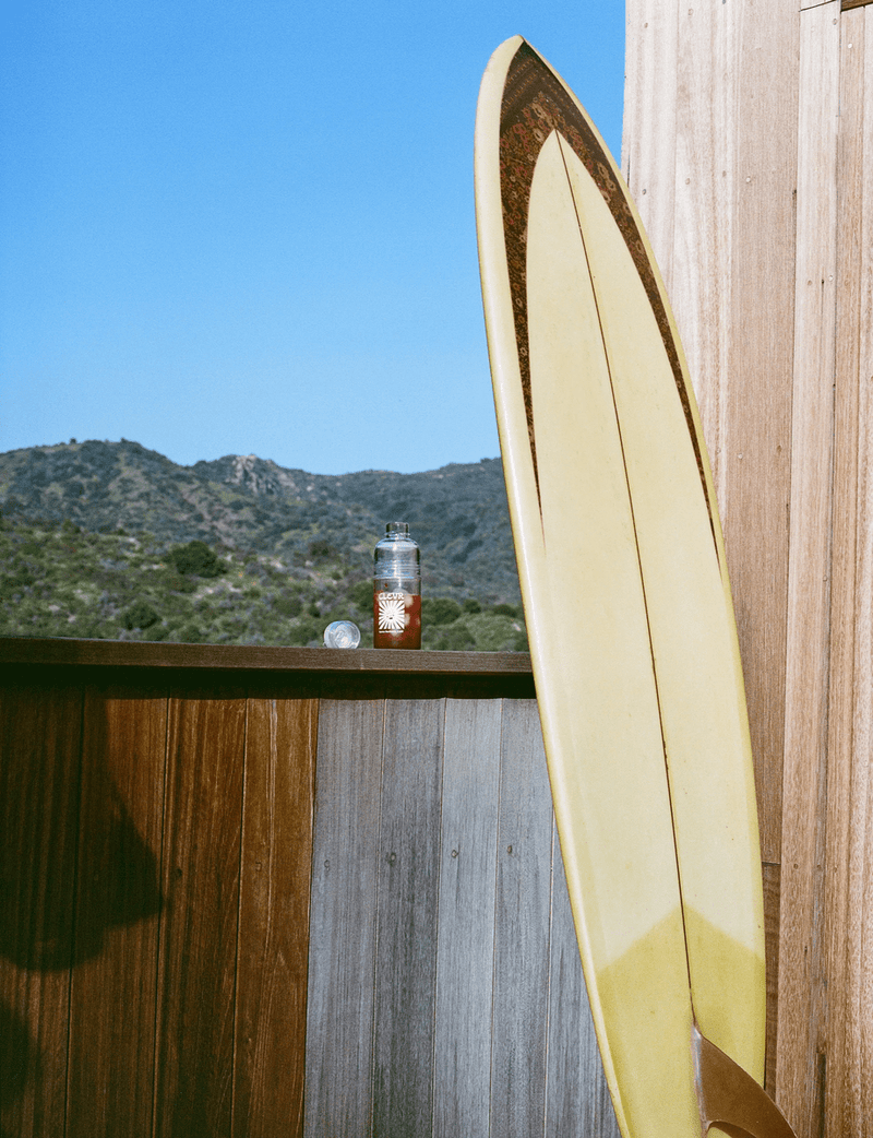 Clevr Shaker Bottle pictured outside on a deck with a surf board