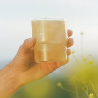 Image of hand holding Clevr Yuzu SuperTea outside
