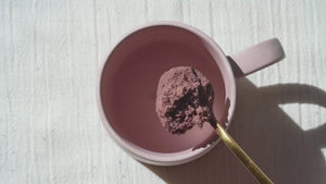 Person making Clevr SuperLatte by adding powder to a mug, pouring water in, and frothing it